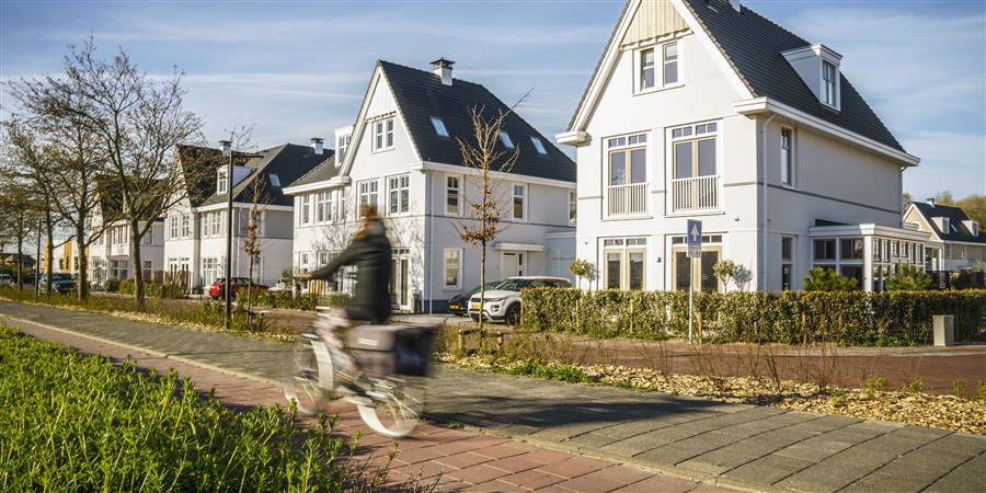 Fietster rijdt door een dure villawijk in Noordwijk.