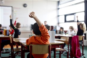 Kinderen steken hun hand op in de klas