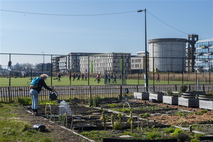 Meisje staat in het water dat over de weg Limburgse uiterwaarden instroomt