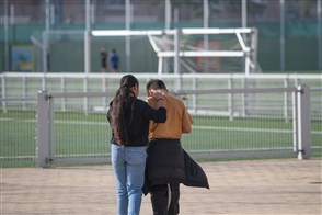 Vrouw en kind in gesprek bij sportveld