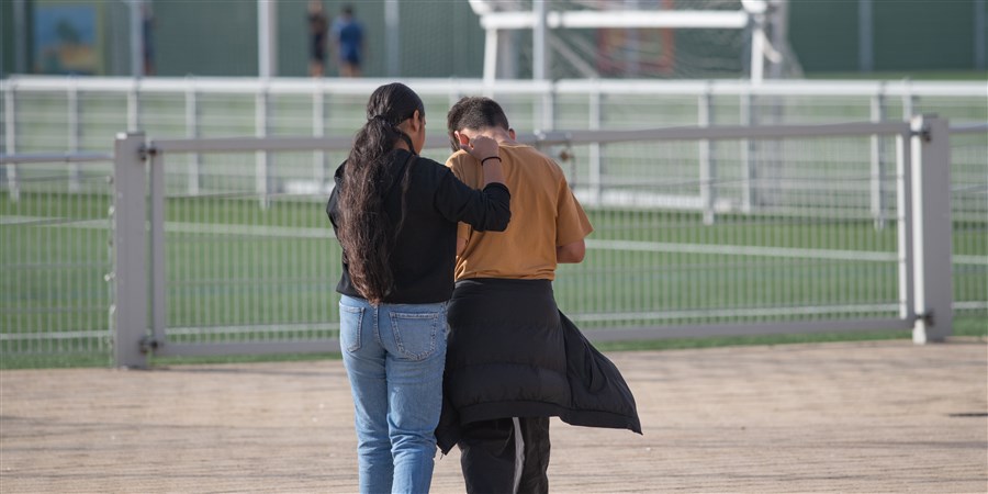 Vrouw en kind in gesprek bij sportveld