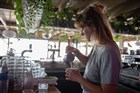 Jonge vrouw werkt achter bar in strandpaviljoen