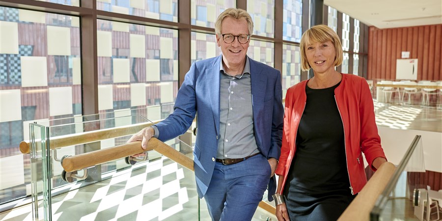 Mike Ackermans en Gabrielle van Mourik staan op de trap in het CBS gebouw in Den Haag.