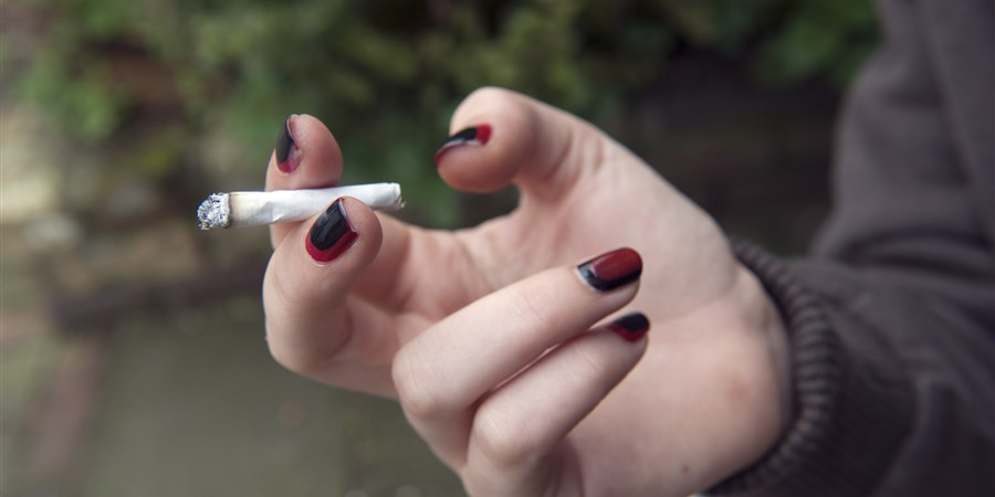 Meisje van 18 jaar rookt haar eerste sigaret.