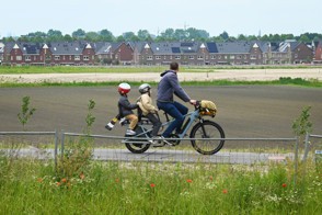 Man fietst met kinderen achterop zijn elektrische fiets