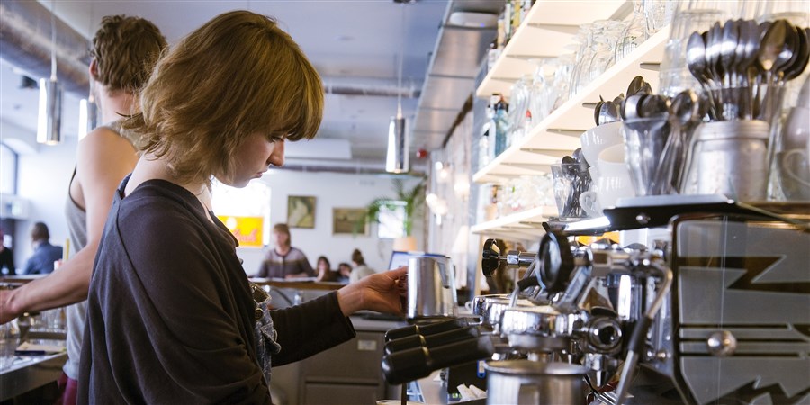 Studente maakt koffie in cafe