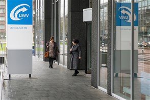  De Heerlense vestiging van CBS, met op de voorgrond een bord met het CBS-logo en de tekst "Centraal Bureau voor de Statistiek".