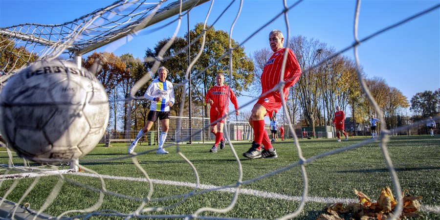 Op een kunstgrasveldje spelen een aantal krasse knarren bij voetbalclub FC Tilburg een partijtje wandelvoetbal