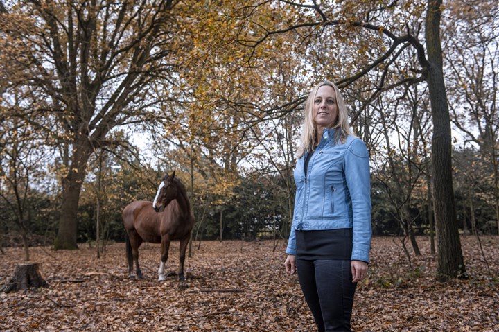 Florianne Matser - Informatie Manager in het bos met paard op de achtergrond