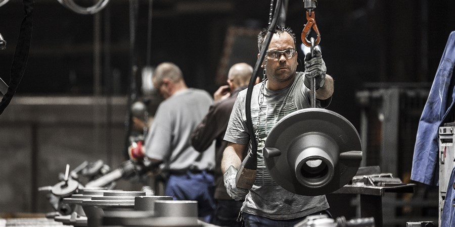 Arbeiders in Heerlense ijzergieterij gieten metalen onderdelen voor vrachtwagens etc