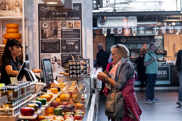 Een vrouw die kaas koop bij een kaas kraam in de markthal in Rotterdam