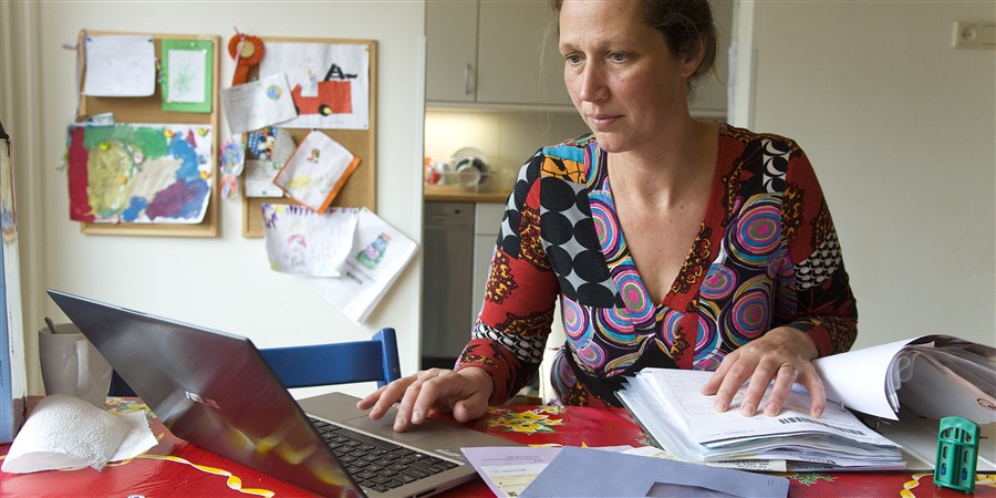 vrouw bezig haar aangifte belastingen te doen op laptop
