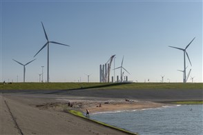 Strand met op de achtergrond windmolens