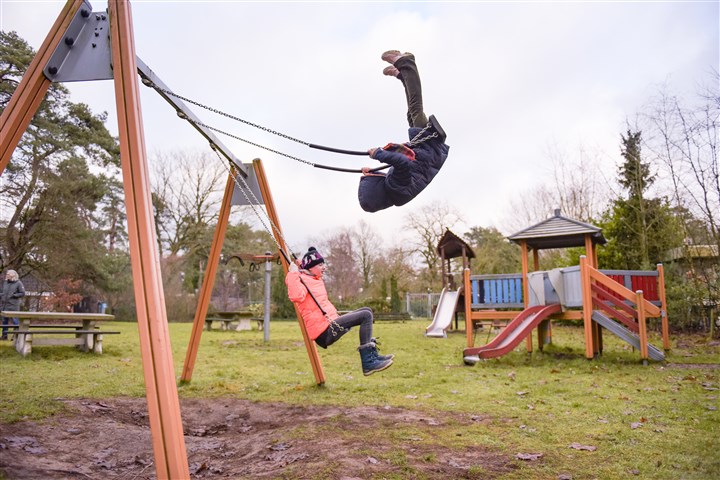 Kinderen aan het schommelen in een speeltuin
