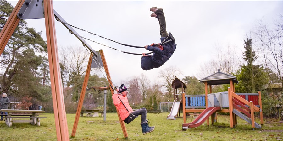 Kinderen aan het schommelen in een speeltuin
