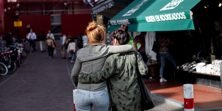 twee vrouwen (lesbisch) die arm om arm met elkaar lopen