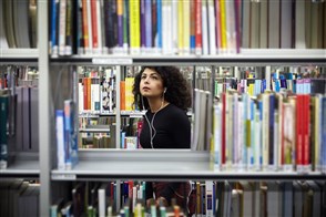 Dame zoekt in een kast met boeken