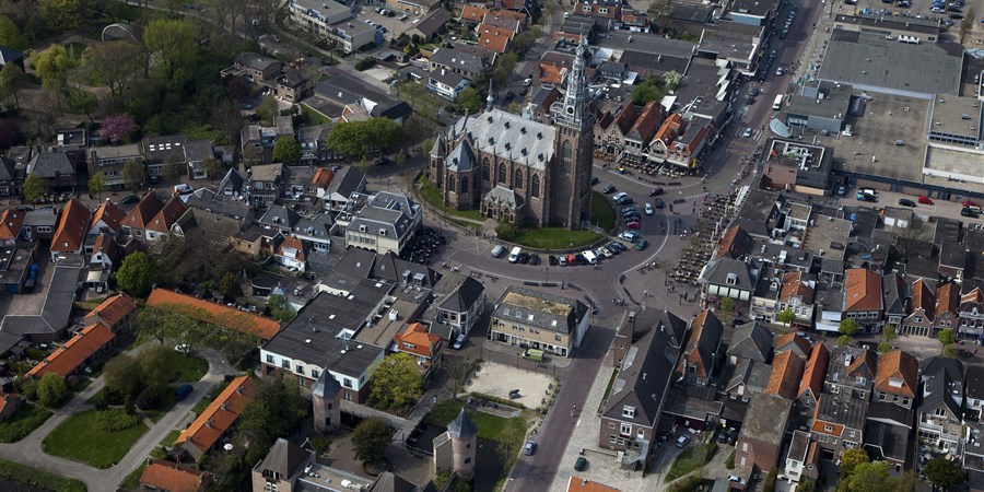 Luchtfoto van Schagen een Westfriese stad, met aan de Markt de Grote Kerk en het Slot Schagen (herbouwd, met authentieke torens)