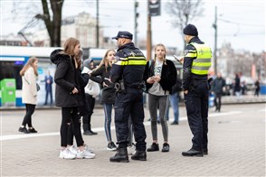 Twee politieagenten die bij een groep meisjes staan