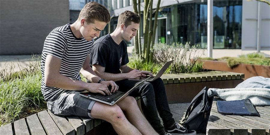 Studenten werken buiten op de stoep van Erasmus universiteit