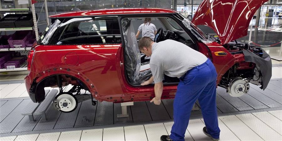 foto: monteur aan de slag in een autofabriek