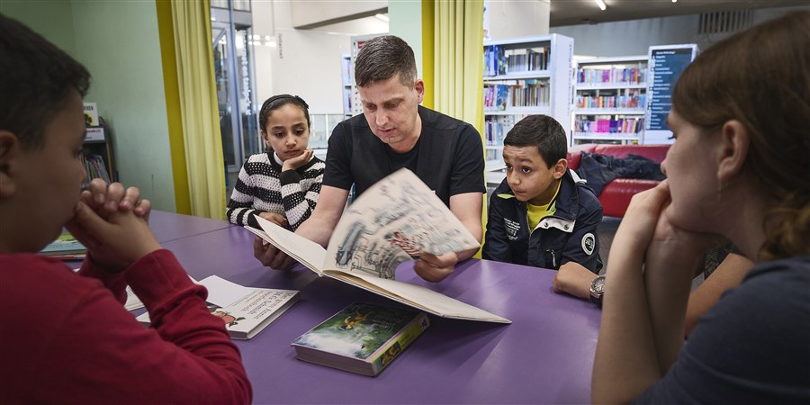 Man leest voor aan kinderen in blbliotheek