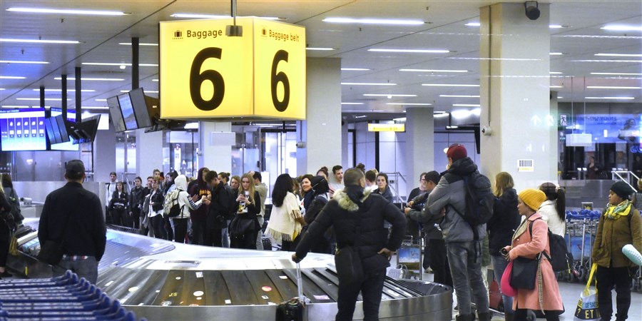Passagiers wachten op hun bagage op de luchthaven