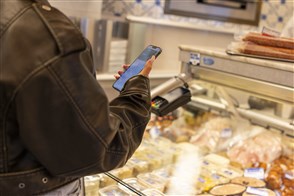 Dagelijks leven in Brabant, iemand rekent met een mobiele telefoon af in een winkel