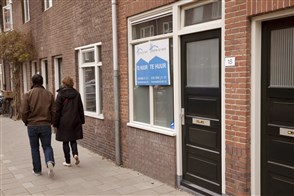 The Heerlen office of Statistics Netherlands, with a sign in the foreground displaying its logo and the full Dutch name in text: Centraal Bureau voor de Statistiek.