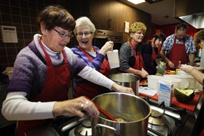 Lachende ouderen dames aan het koken
