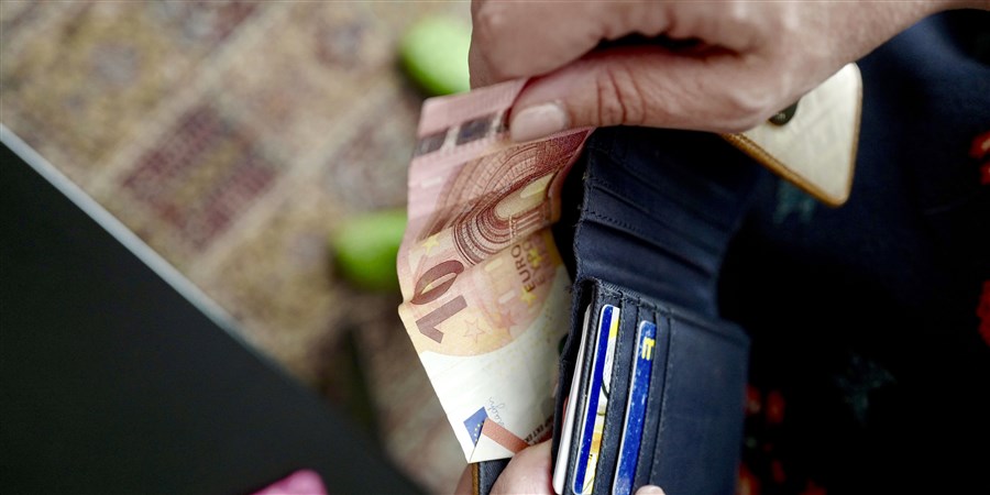 Hand haalt geld uit portemonnee