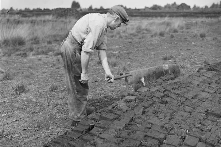 Een landarbeider is bezig met turfsteken