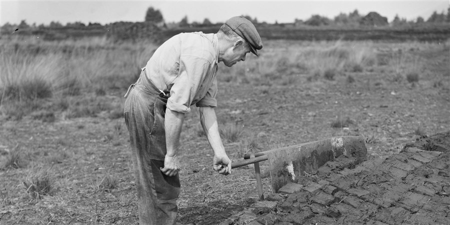 Een landarbeider is bezig met turfsteken