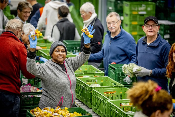 Vrijwilligers van de Voedselbank in Haaglanden pakken voedselpakketten in