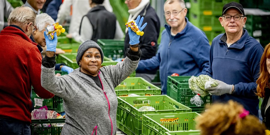 Vrijwilligers van de voedselbank in Den Haag pakken voedselpakketten in