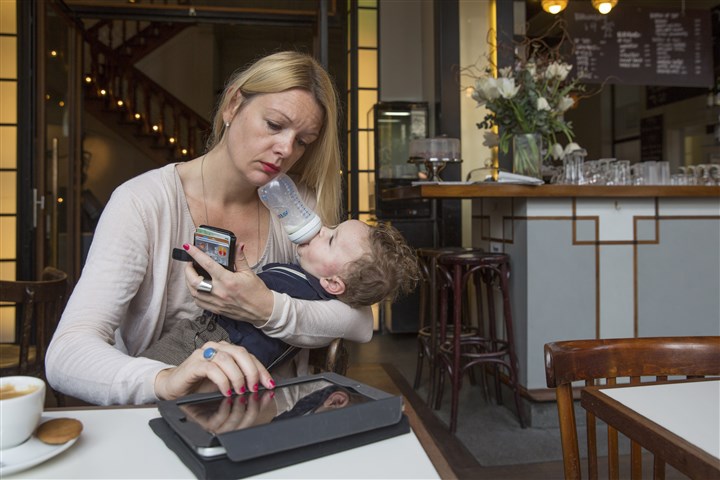 Werkende moeder geeft haar eerste kind de fles