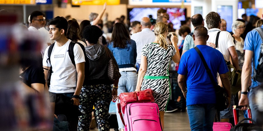 Reizigers in de vertrekhal op Schiphol