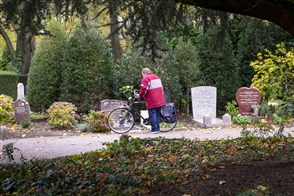 Een man staat te rouwen bij een graf op begraafplaats Crooswijk in Rotterdam