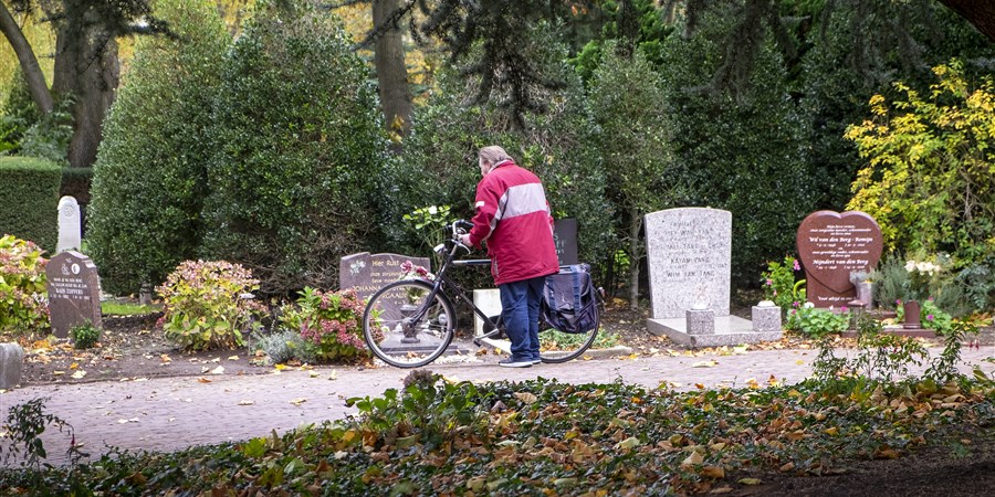Een man staat te rouwen bij een graf op begraafplaats Crooswijk in Rotterdam