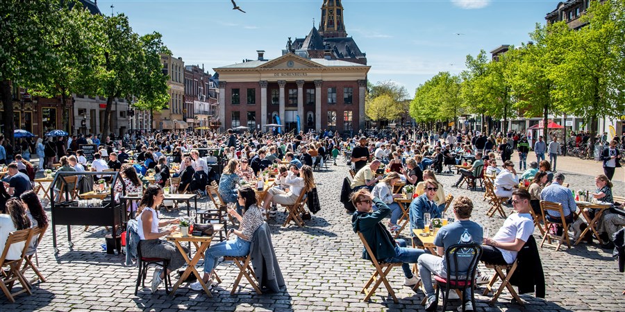 Cafés and restaurants with outdoor seating on a sunny day at Vismarkt in Groningen city.
