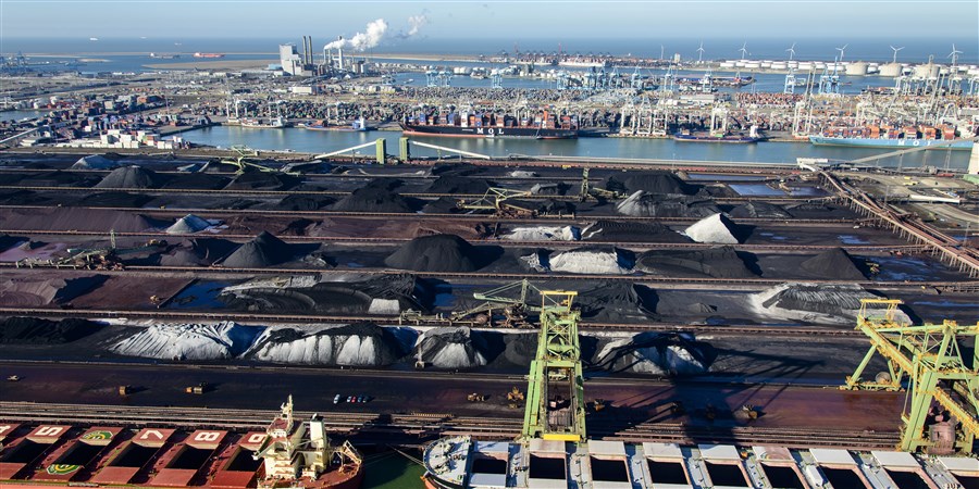 Luchtfoto van de Eerste Maasvlakte met op voorgrond boten met kolen en ijzererts en op achtergrond een elektriciteitscentrale