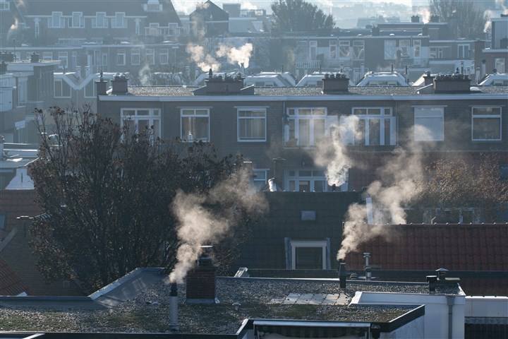 Dampende CV schoorstenen op Haagse daken
