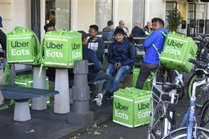 UberEATS fietskoeriers wachten op hun bestelling in het centrum van Den Haag