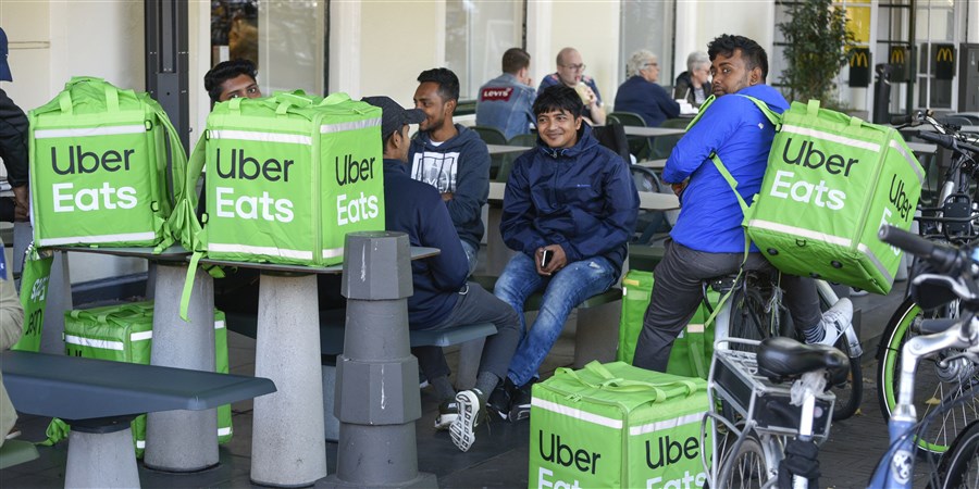 UberEATS fietskoeriers wachten op hun bestelling in het centrum van Den Haag