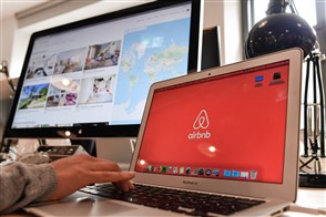 Person behind computer wants to book a digital service on Airbnb