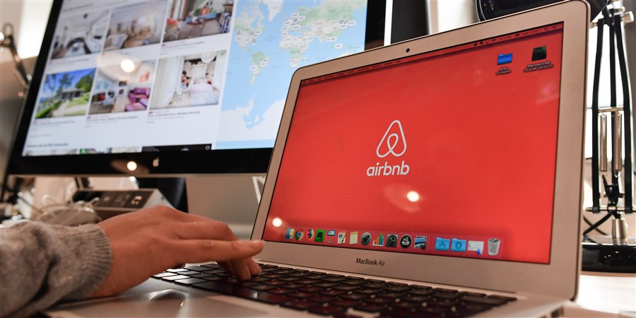 Persoon achter computer wil een digitale dienst boeken bij Airbnb