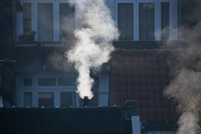 Dampende schoorstenen op Haagse daken