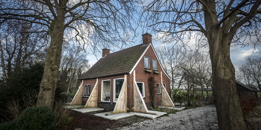 Huis gestut met balken na aardbeving