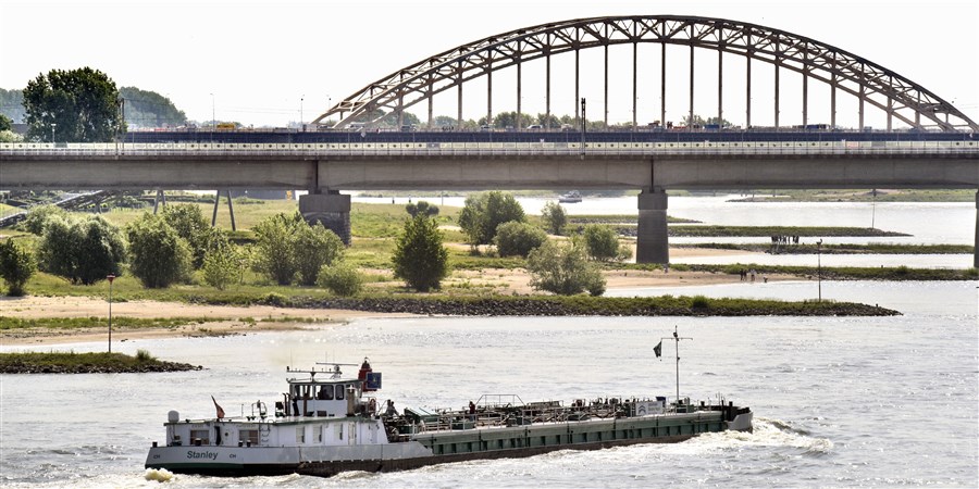 Een binnenvaartschip passeert de nevengeul in de waal ter hoogte van Nijmegen .