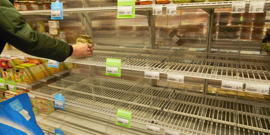 Lege schappen in supermarkt doordat Nederlanders in winkels massaal levensmiddelen hamsteren uit angst voor de uitbraak van corona